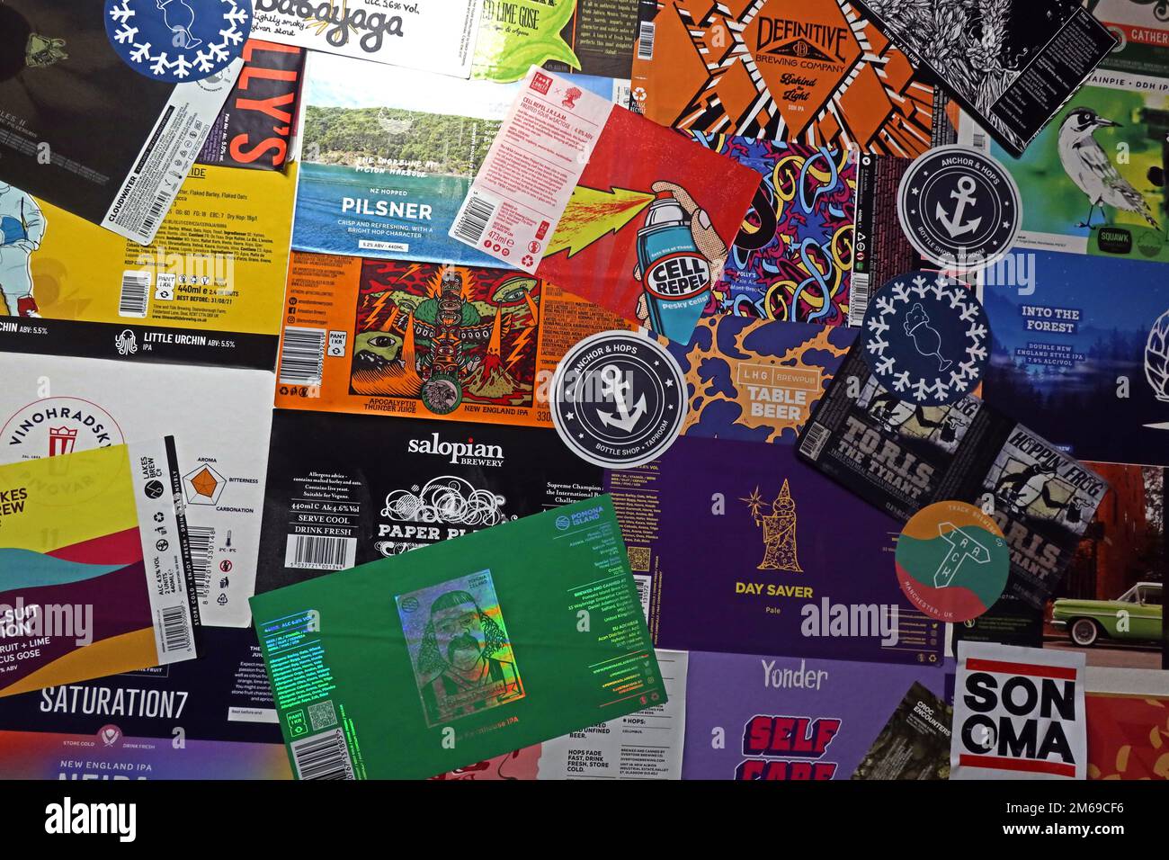 A mix of UK craft beer labels, stuck to a wall, as wallpaper Stock Photo