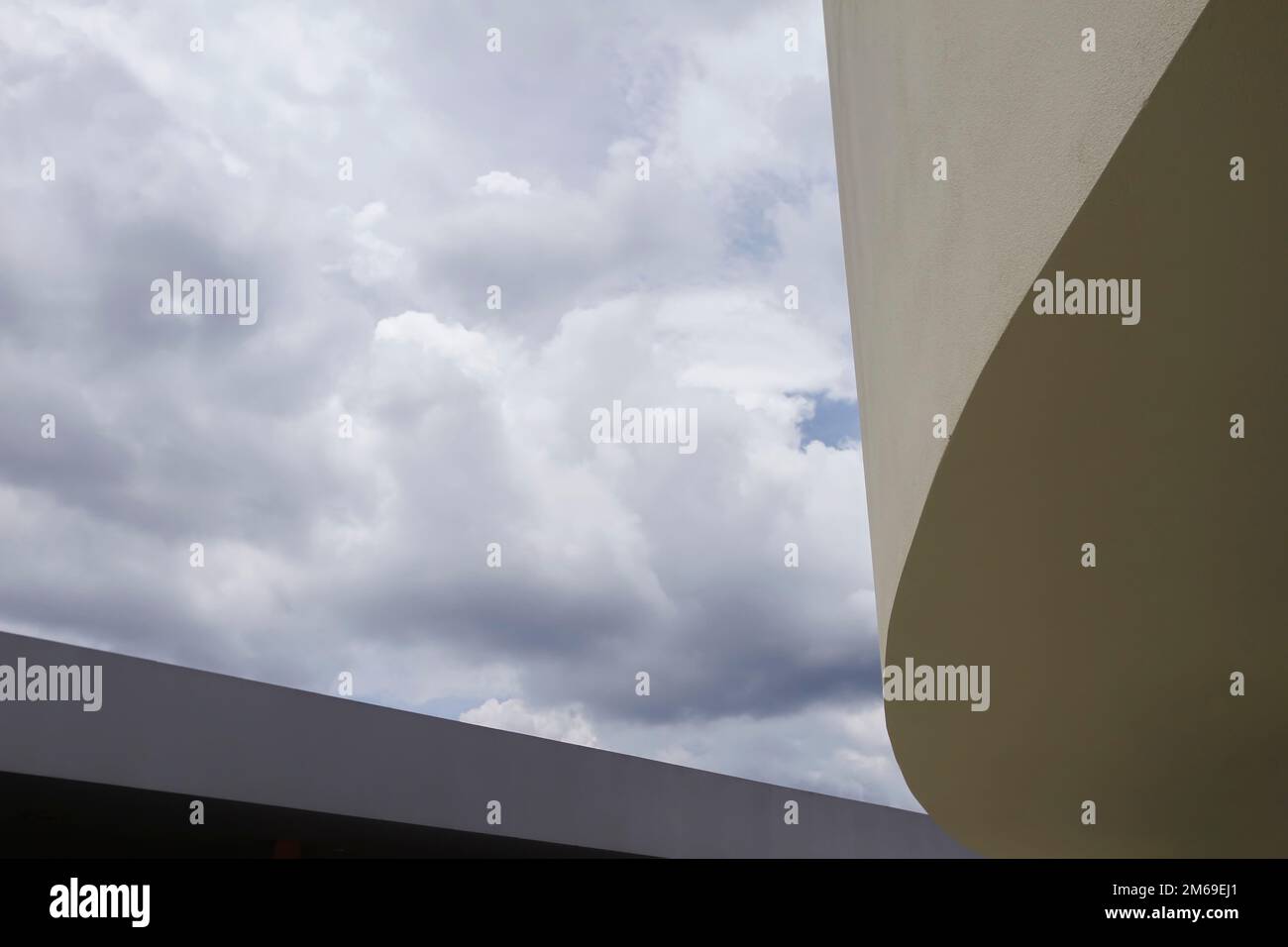 building and architectural detail - curved and straight shapes between clouds Stock Photo