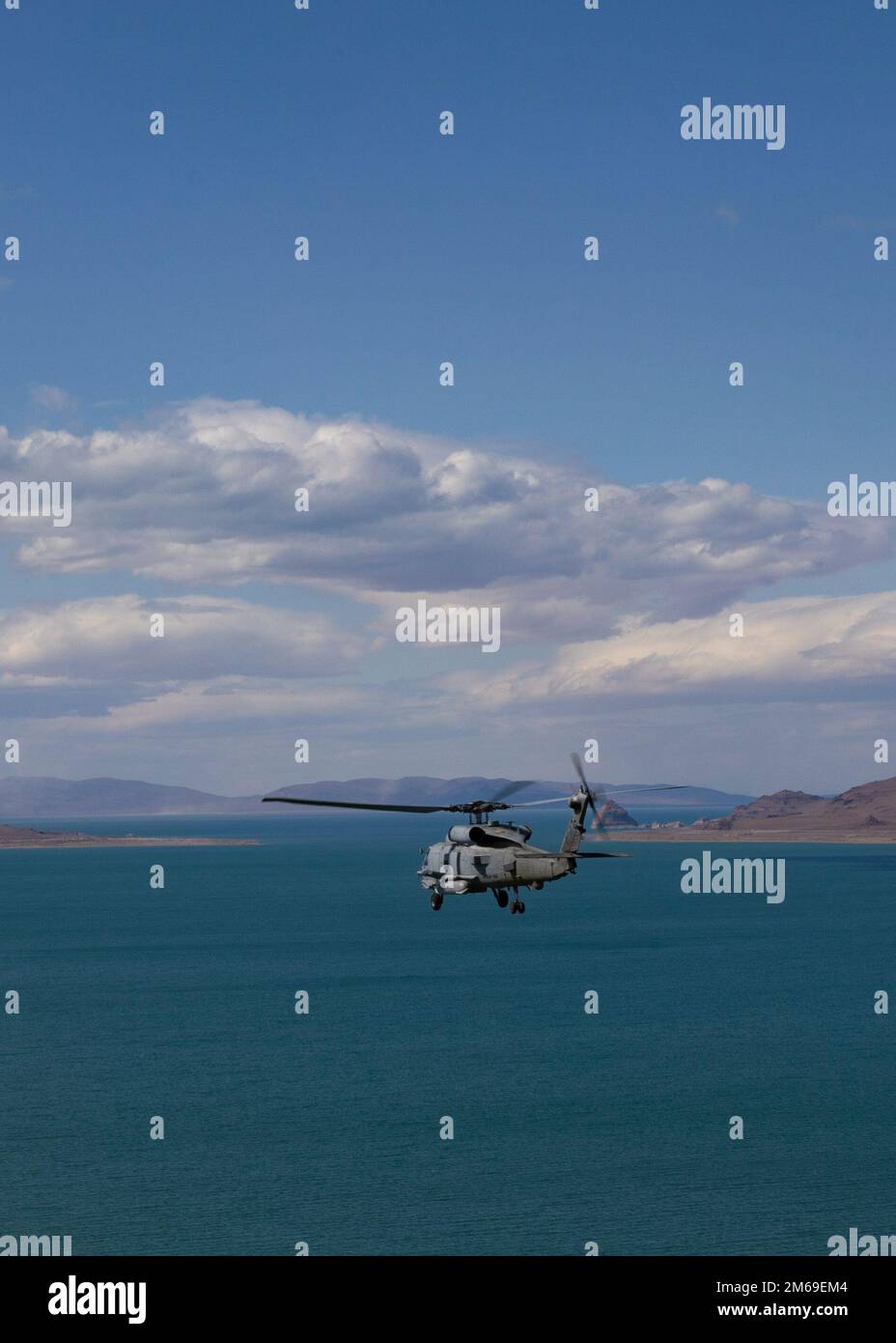 An Mh-60R Seahawk attached to Helicopter Maritime Strike Squadron (HSM) 46 flies a daytime familiarization flight during a training detachment at Naval Air Station Fallon, April 20, 2022. Carrier Air Wing (CVW) 7 is the offensive air and strike component of Carrier Strike Group (CSG) 10 and the George H.W. Bush CSG. The squadrons of CVW-7 are Strike Fighter Squadron (VFA) 143, VFA-103, VFA-86, VFA-136, Electronic Attack Squadron (VAQ) 140, Carrier Airborne Early Warning Squadron (VAW) 121, HSC-5, and Helicopter Maritime Strike Squadron (HSM) 46. Stock Photo