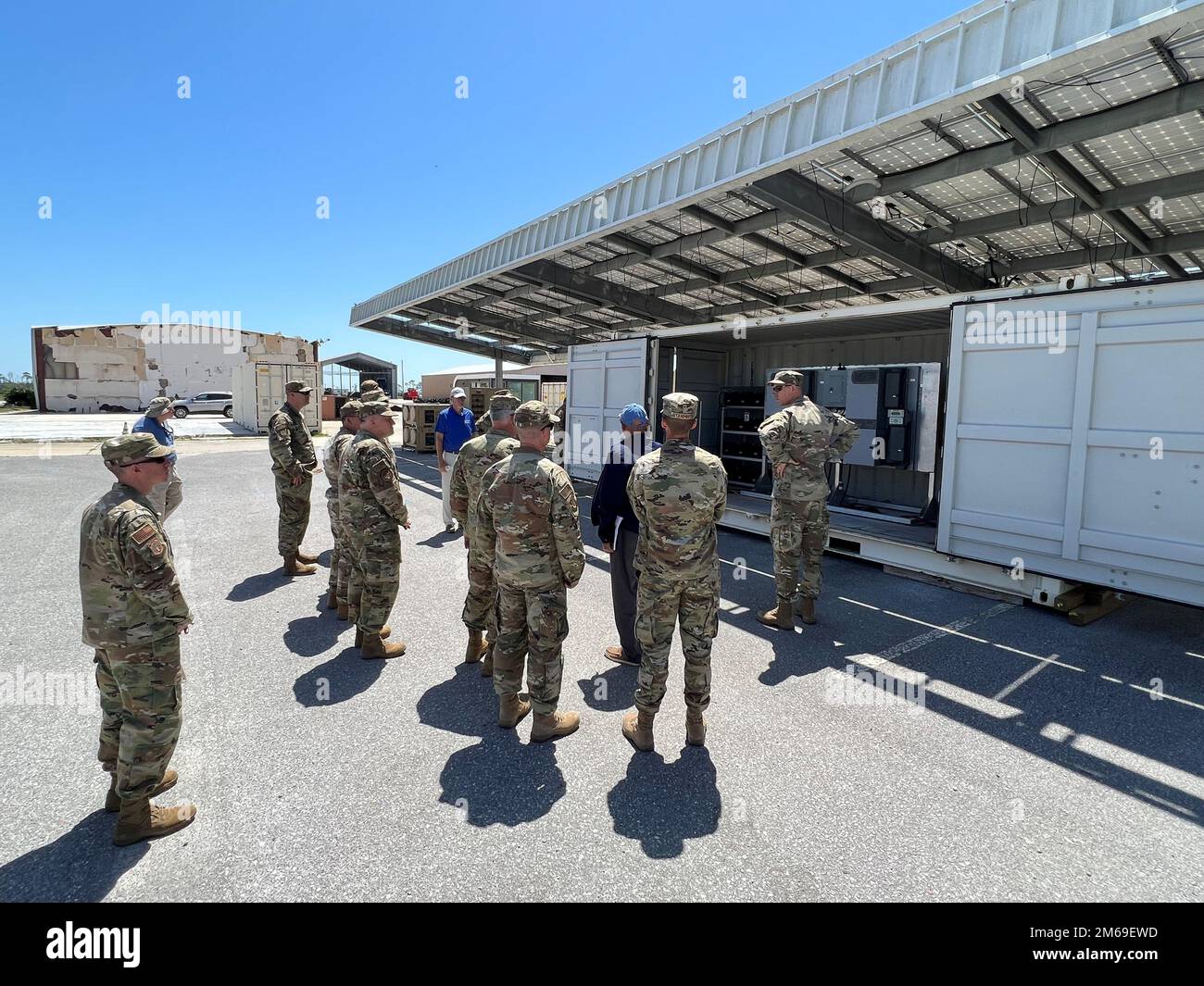 Maj. Gen. John Allen, Air Force Civil Engineer Center commander, and other leaders looks on as AFCEC Engineer Reza Salavani describes the Solar Carport during a visit to the 9700 Area at Tyndall Air Force Base, Florida, on April 20, 2022. Constructed in 2010, the carport was funded by the Air Force Research Lab-Advanced Power Technology Office. The steel structure proved its strength in 2018 when, following a direct hit by the Category 5 storm Hurricane Michael,133 of its 140 panels remained intact. The system currently provides power for a variety of things including tools, test equipment and Stock Photo