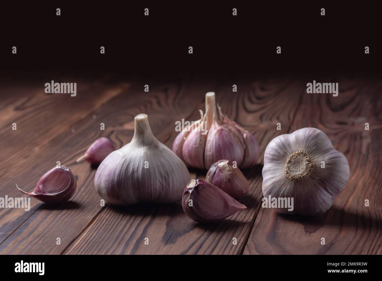 Garlic cloves and bulb on wooden table. Fresh peeled garlics and bulbs ...