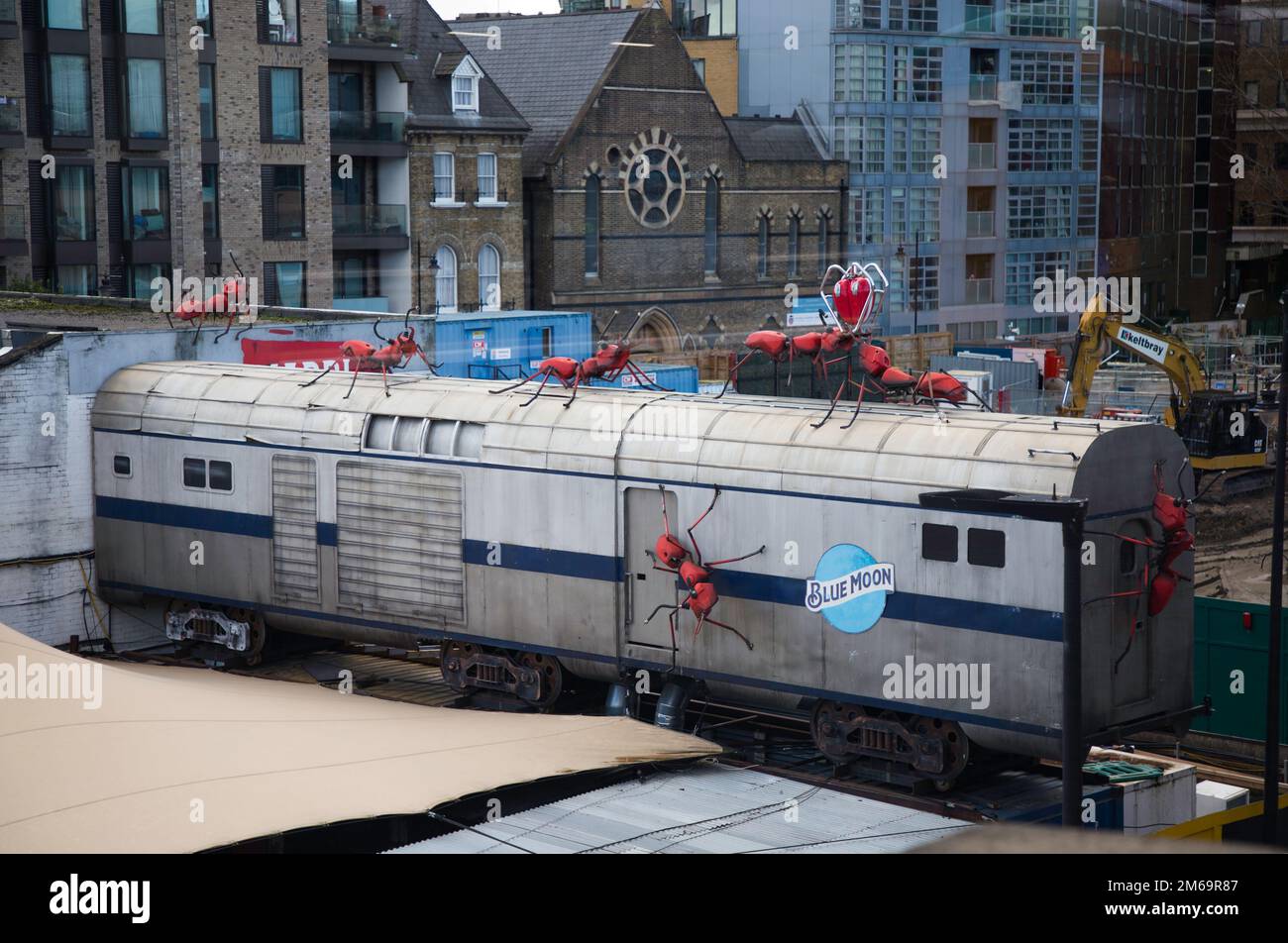 Red ant sculptures crawling over a train carriage at a restaurant in London Bridge, London,UK Stock Photo