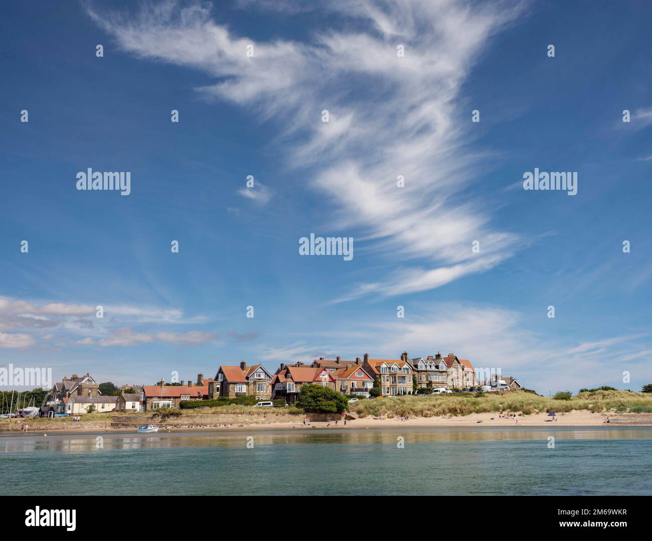 The village of Alnmouth reflected in the waters of the River Aln on a summer afternoon, Northumberland, England Stock Photo
