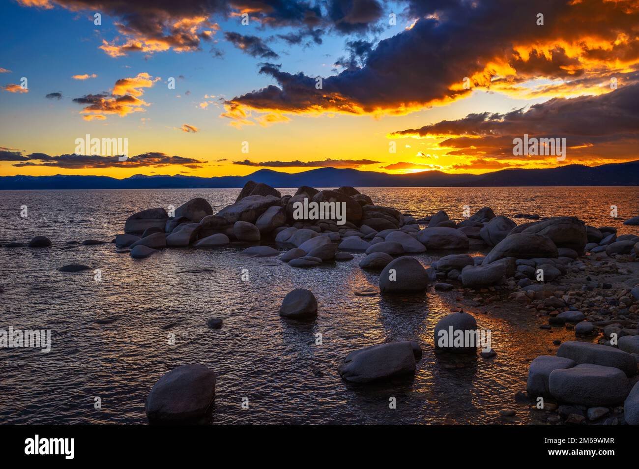 Sunset above rocky beach of Lake Tahoe in California Stock Photo