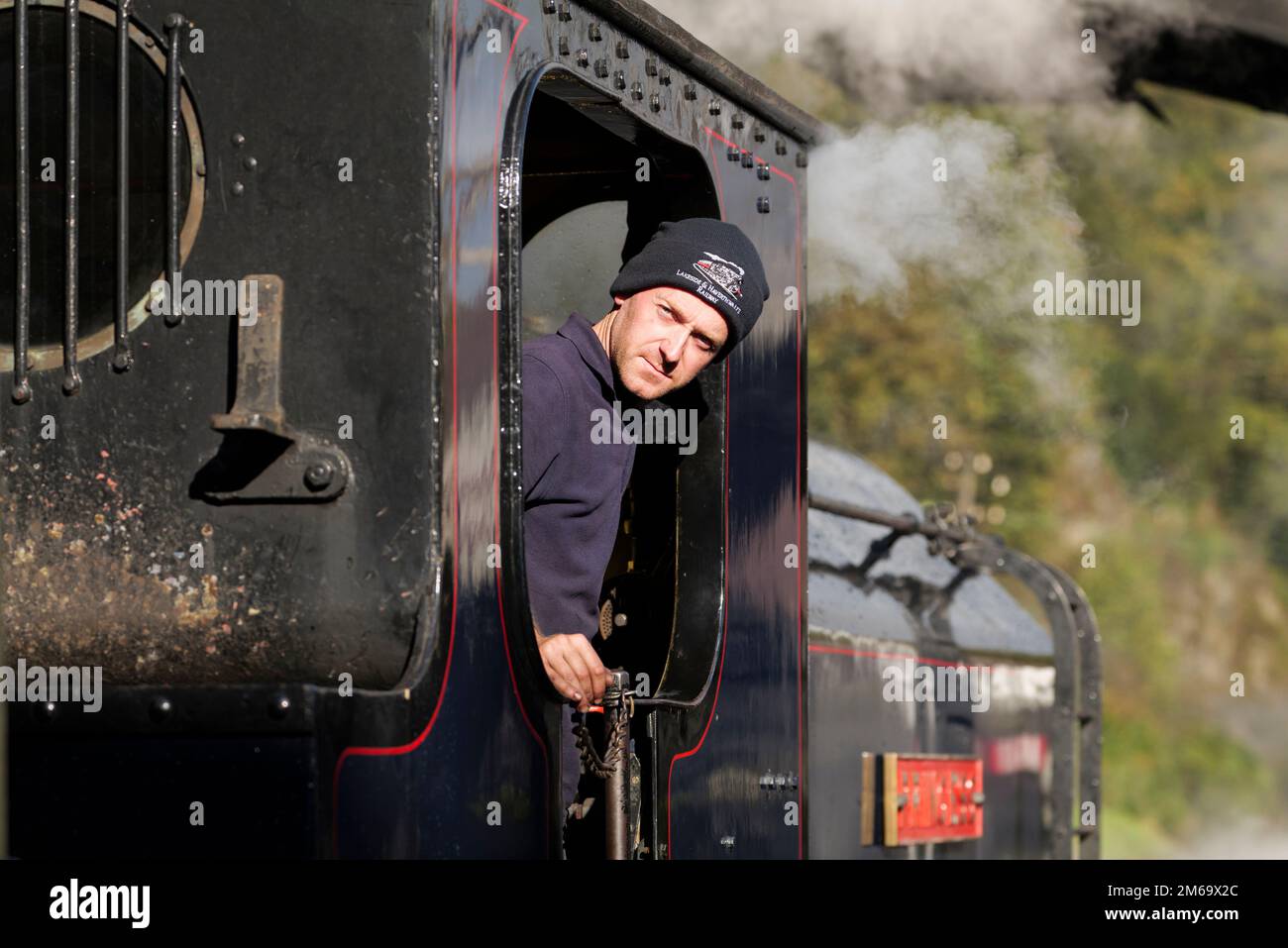 Driver in the cabin of a steam train at Haverthwaite Station on the Lakeside & Haverthwaite Railway line, Cumbria, England Stock Photo