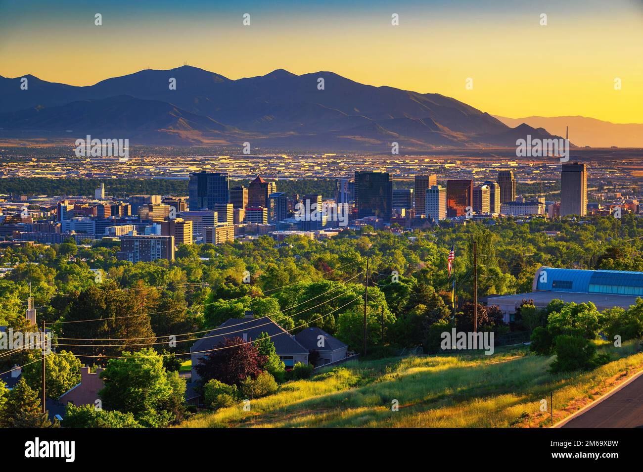 Salt Lake City skyline at sunset with Wasatch Mountains in the background, Utah Stock Photo