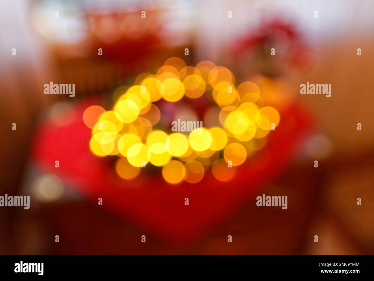 Christmas Wreath with yellow Fairy Lights and red Advent Candles Extremely Blurred Background Stock Photo