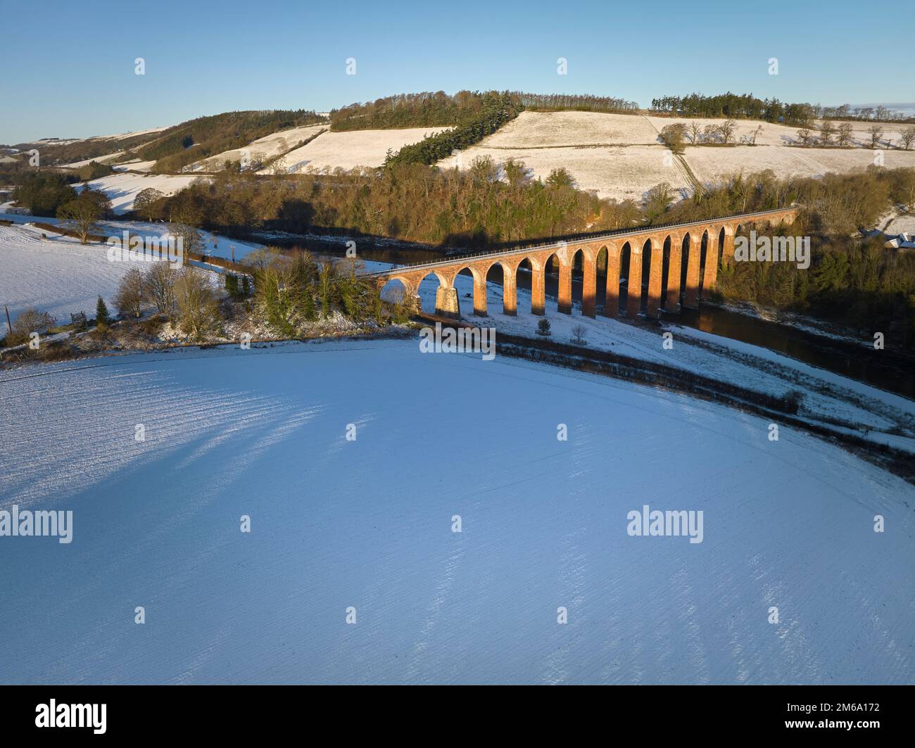 Aerial view of the Leaderfoot Viaduct crossing the River Tweed with the remains of Trimontium Roman Camp on a snowy winter day. Stock Photo