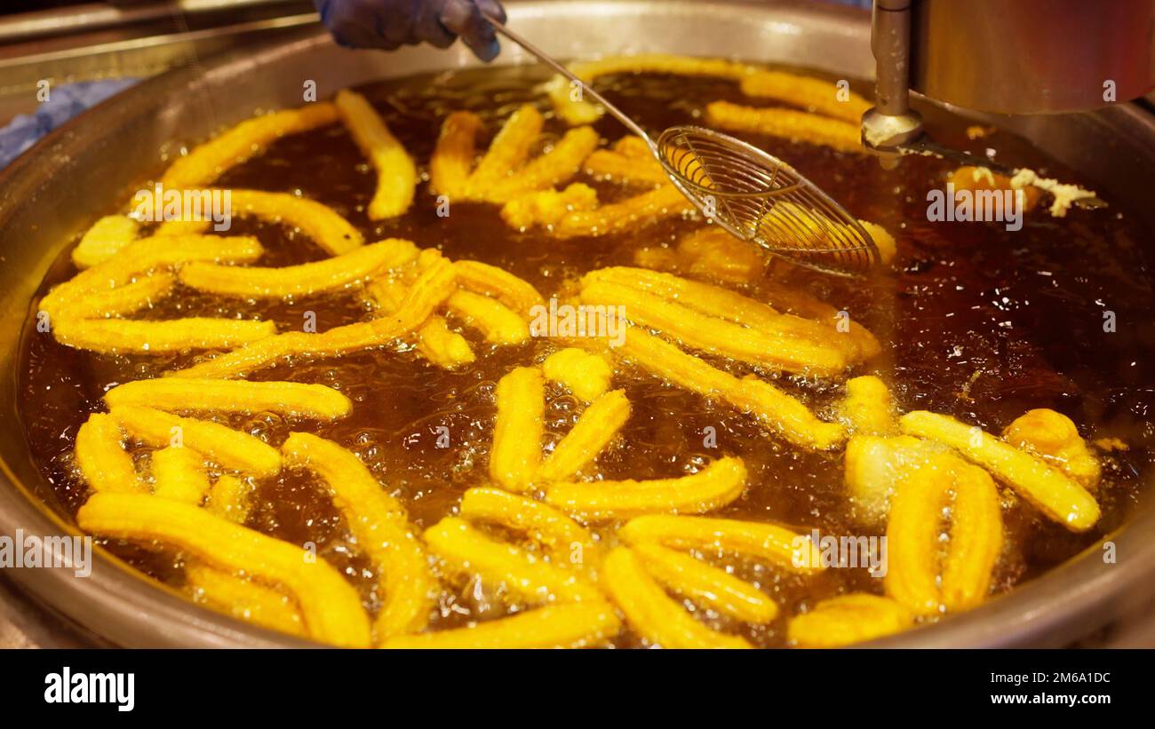 Frying Mexican churros in hot oil Stock Photo Alamy