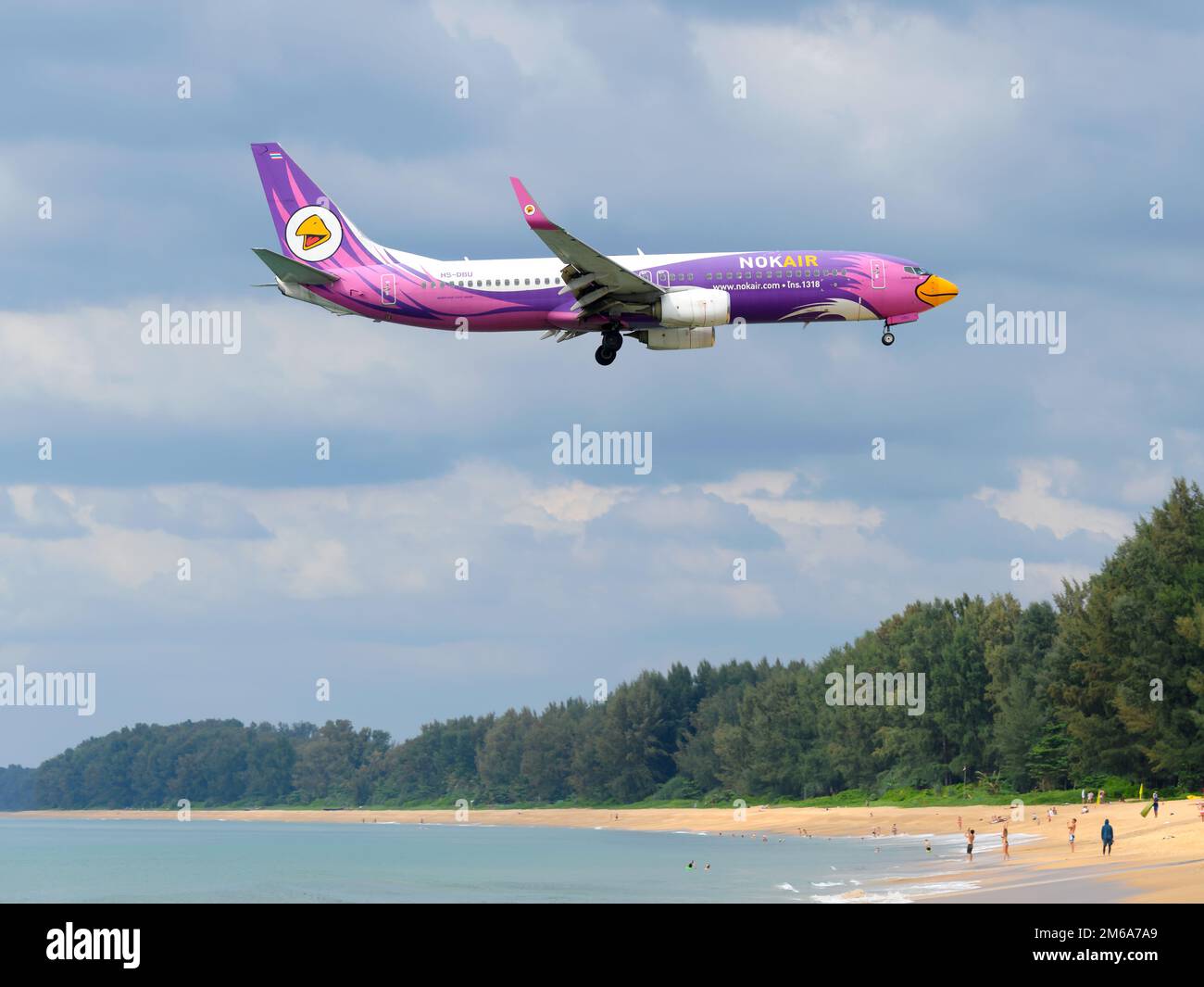 Nok Air Boeing 737 aircraft flying over Mai Khao Beach near Phuket Airport. Airplane 737-800 of NokAir Thailand (Nok Air Thailand). Stock Photo