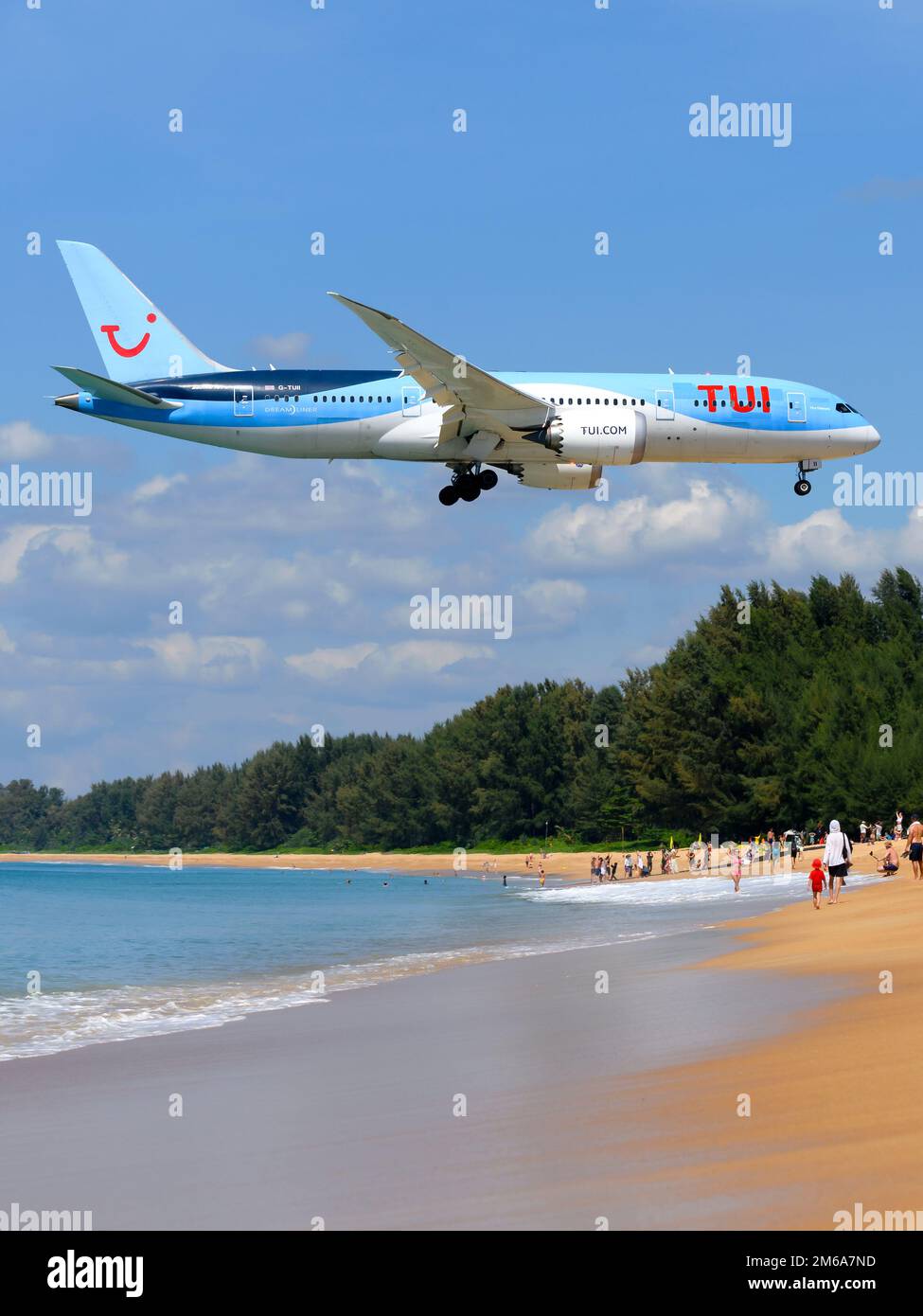 TUI Airways Boeing 787 aircraft over Mai Khao Beach near Phuket Airport. Airplane 787-8 flying over touristic beach. Plane 787. Stock Photo