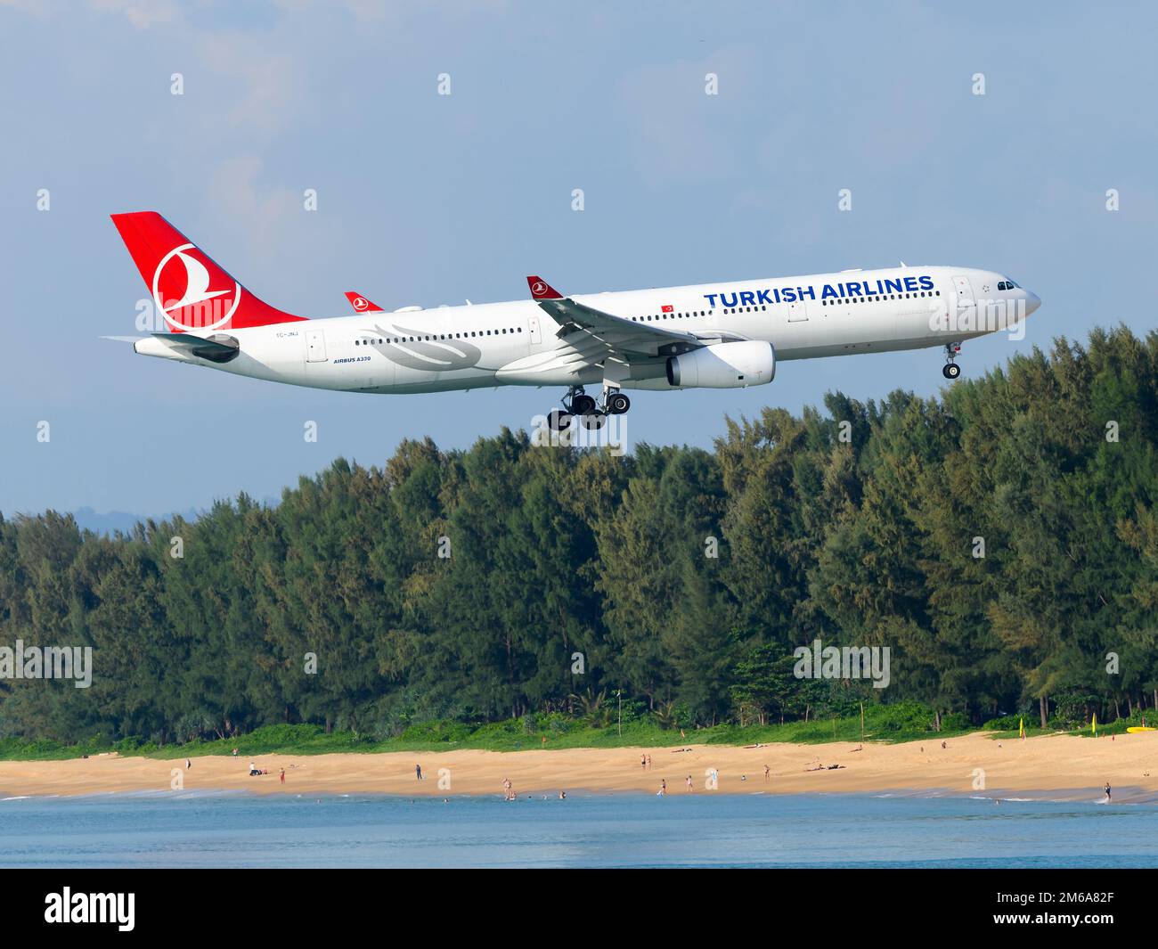 Turkish Airlines Airbus A330-300 aircraft over Mai Khao Beach. Airplane A330 of Turkish over Phuket Airport Beach. Plane above beach. Stock Photo