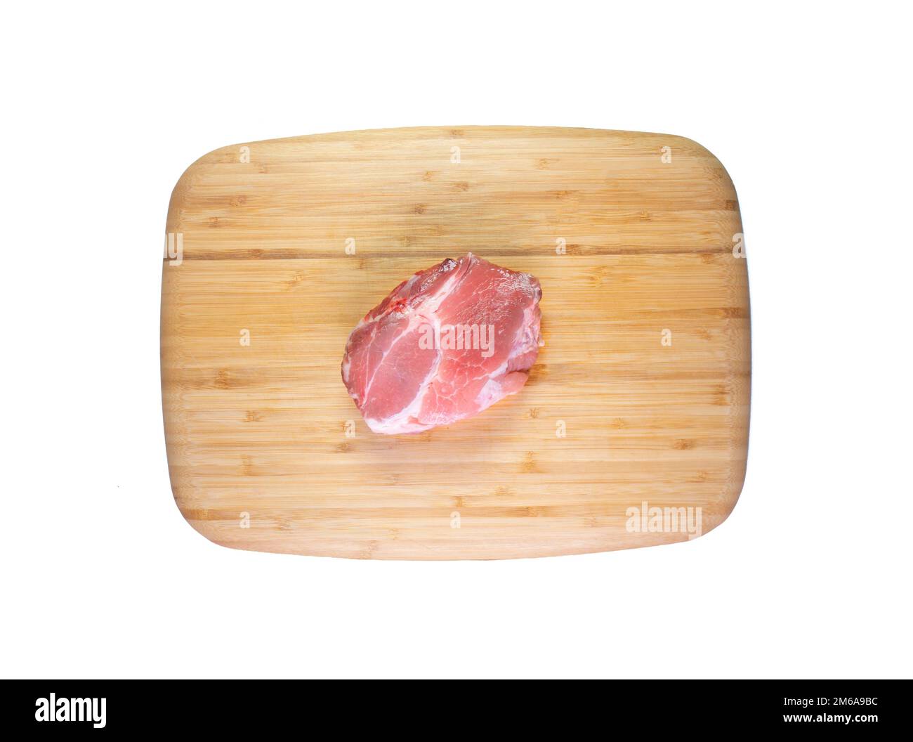 Pork loin meat on a wooden board in white background. Stock Photo