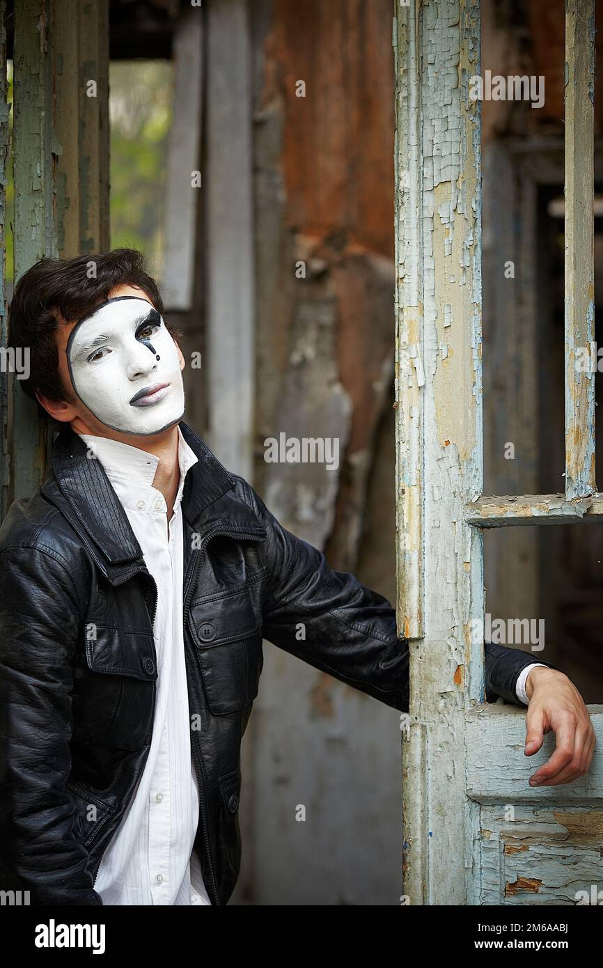 Guy mime against the old wooden door. Stock Photo