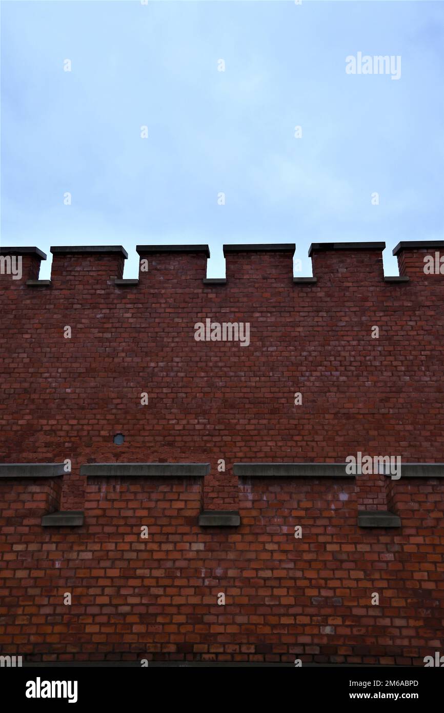 Battlements on a red brick wall Stock Photo