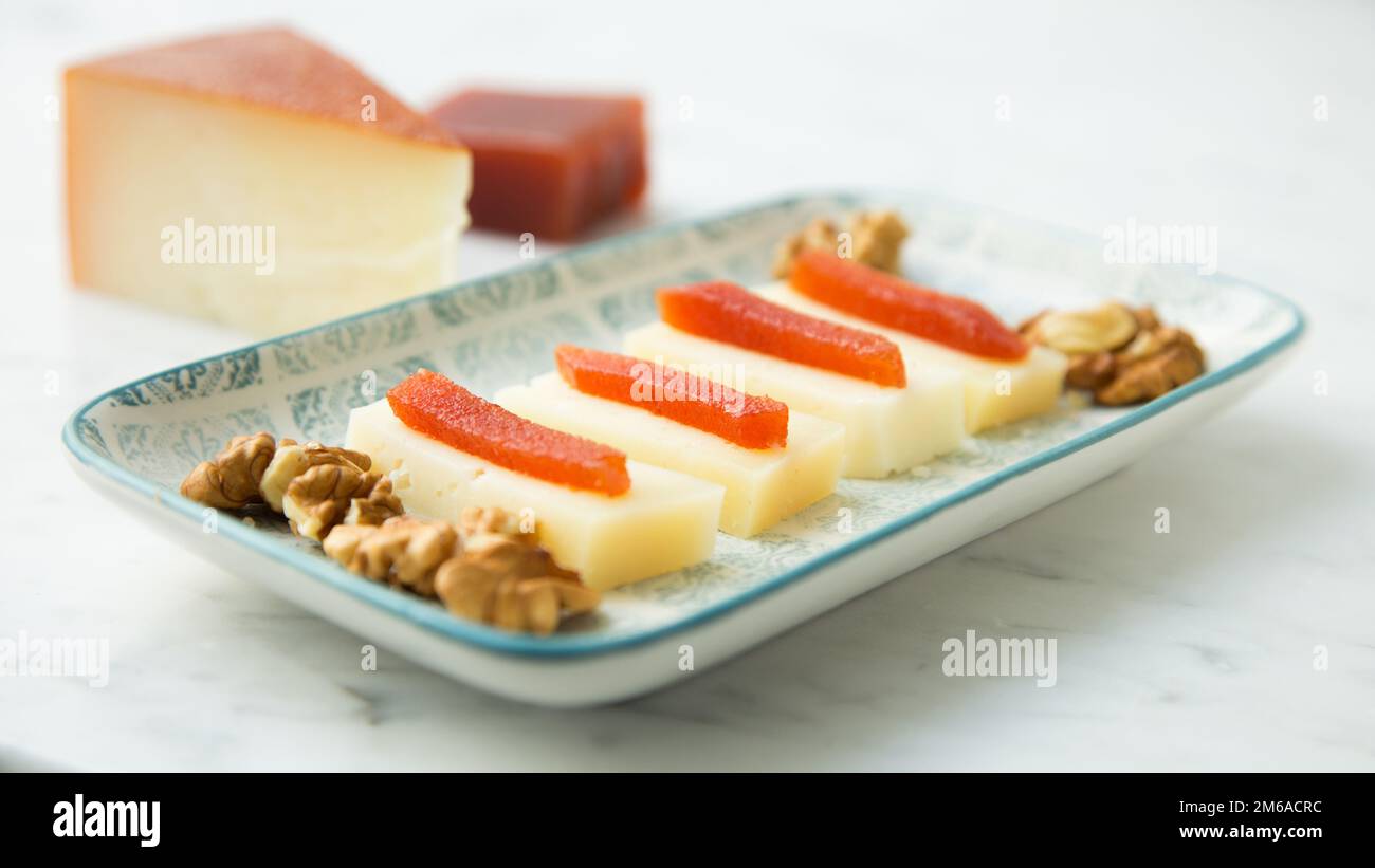 Organic cheese on a wood table with quince jelly and wallnuts Stock