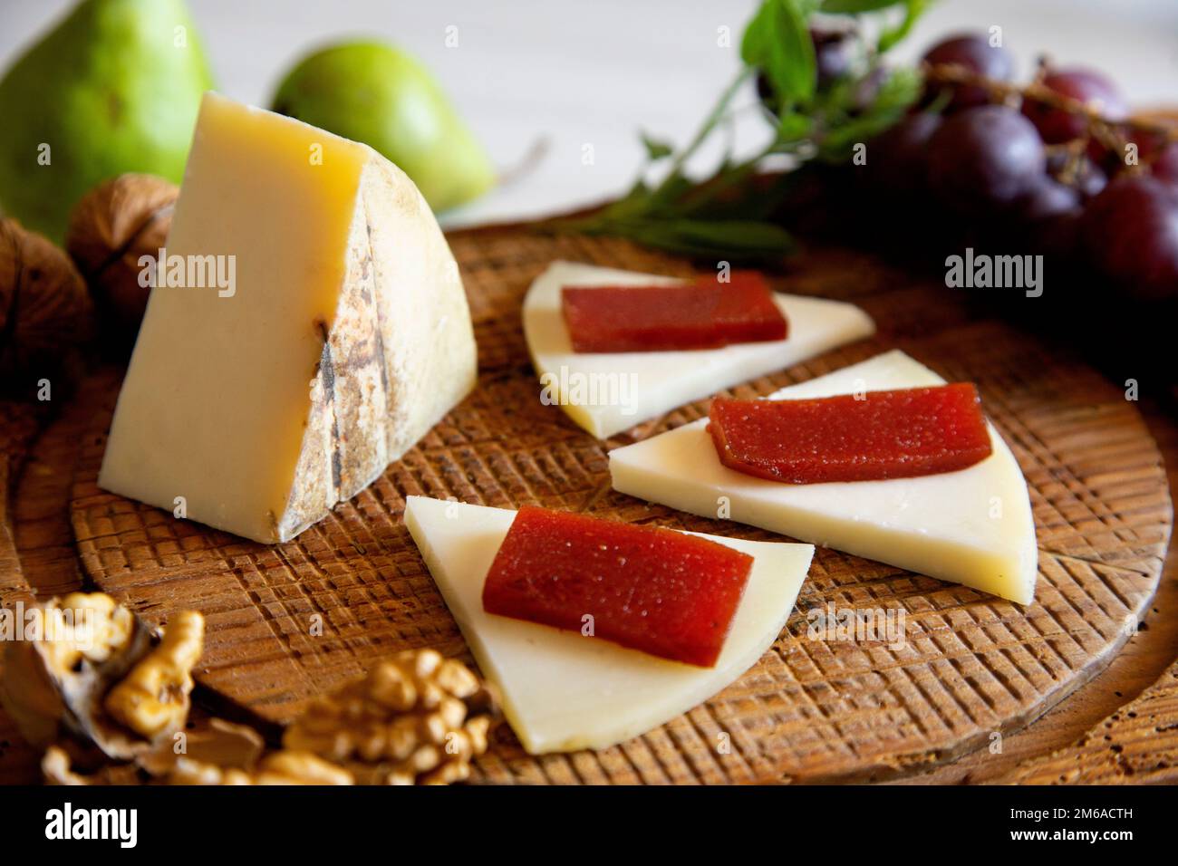 Organic cheese on a wood table with quince jelly and wallnuts Stock