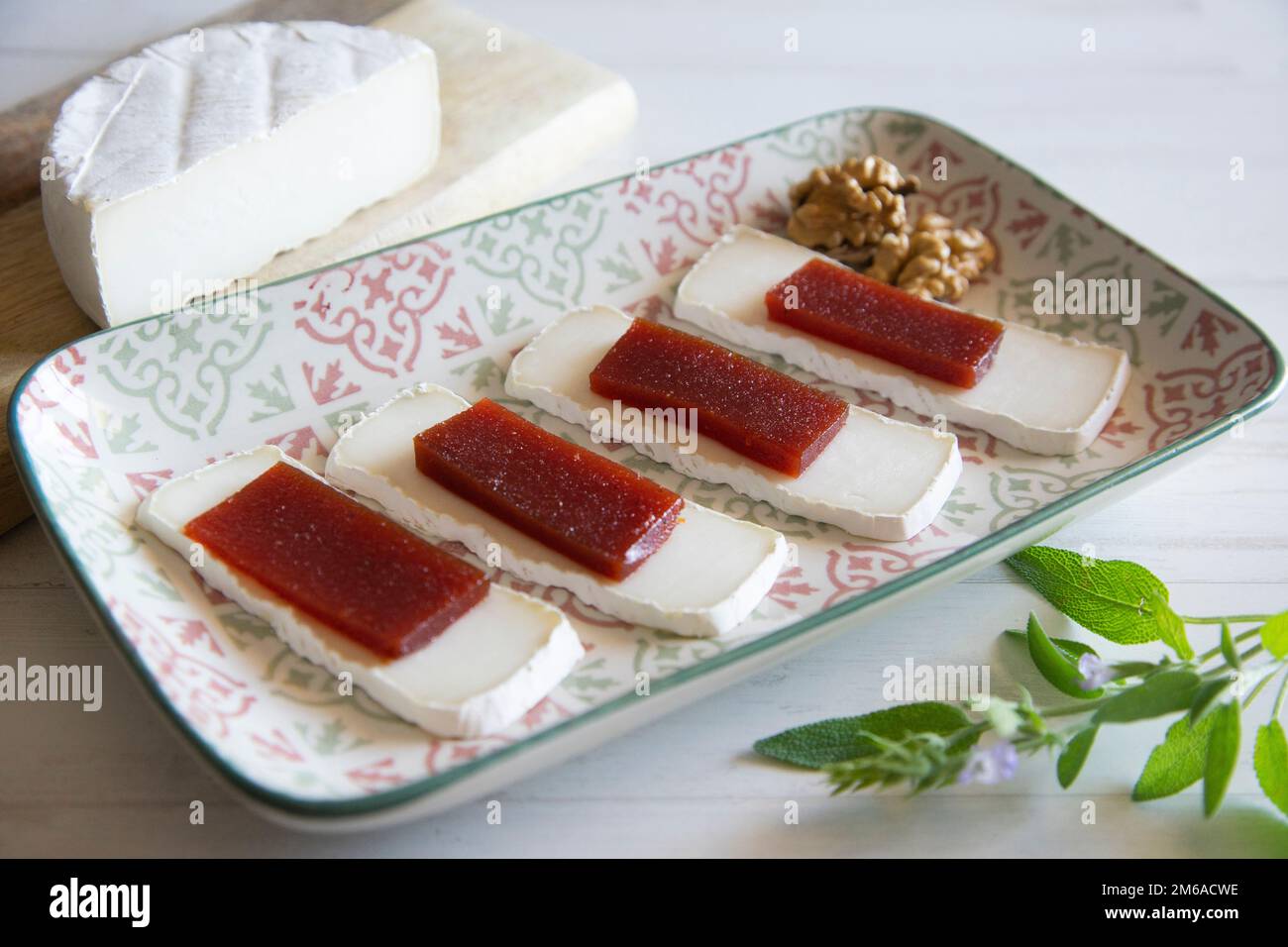 Organic cheese on a wood table with quince jelly and wallnuts Stock