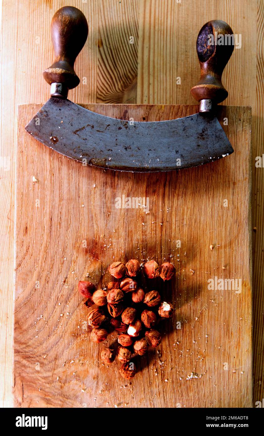 https://c8.alamy.com/comp/2M6ADT8/vintage-cutter-knife-and-nuts-on-wooden-board-chopping-nuts-for-healthy-dessert-2M6ADT8.jpg