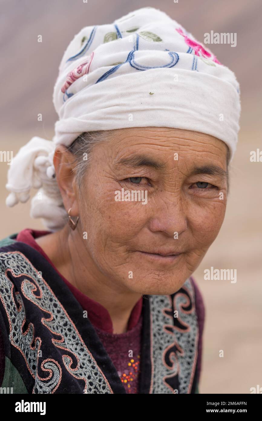 Murghab district, Gorno-Badakshan, Tajikistan : 08 27 2019 : Portrait of old Kyrgyz woman with blue eyes and white head scarf along the Pamir Highway Stock Photo