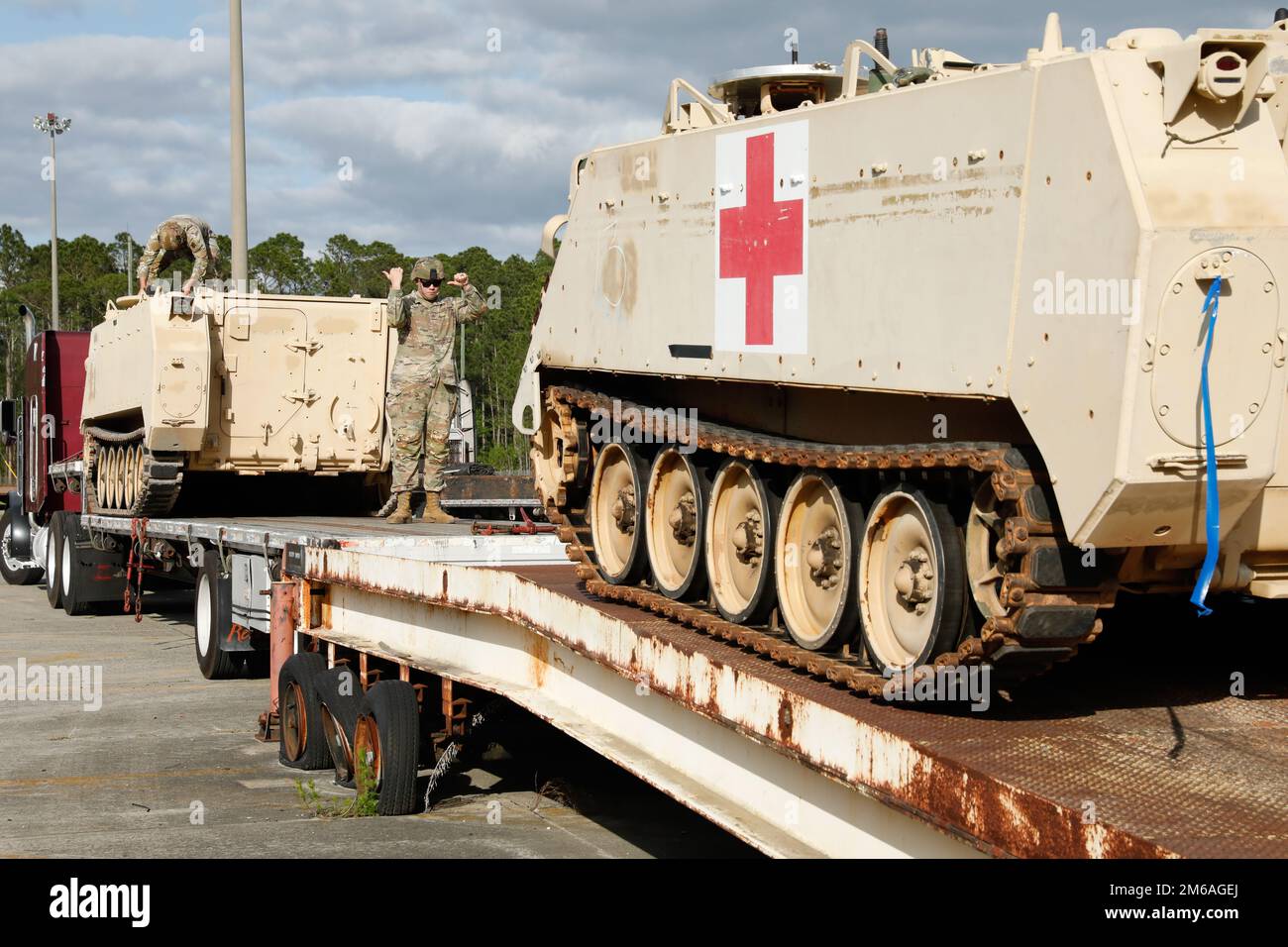 A U.S. Army Soldier assigned to the 3rd Infantry Division ground guides a Soldier driving an M113 Armored Personnel Carrier onto a truck flatbed at Fort Stewart, Georgia, April 21, 2022. The 3rd ID divested the armored vehicles to support the Presidential Response requirements for the European Theater of Operations for the purpose of providing immediate military assistance to Ukraine. Stock Photo