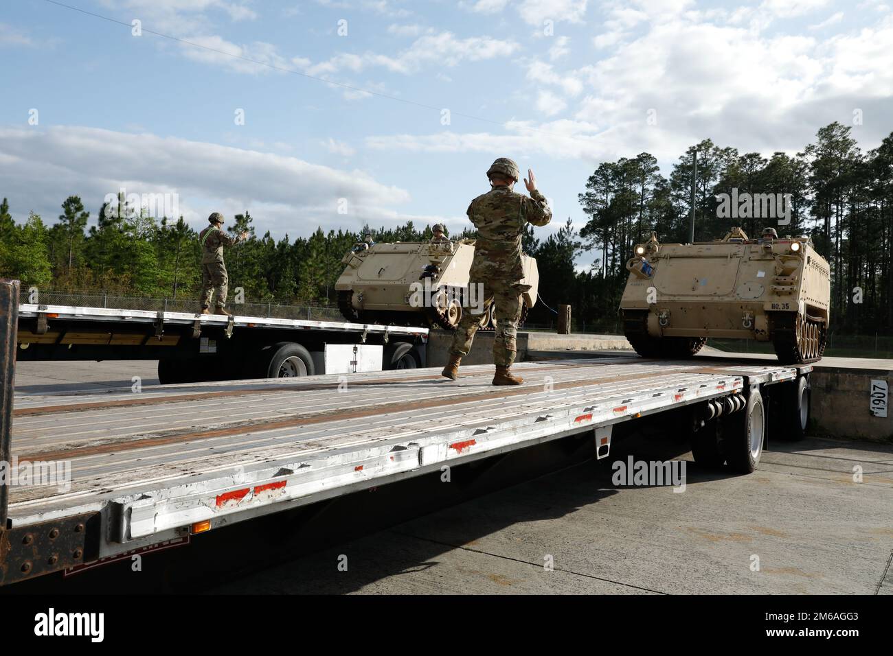 U.S. Army Soldiers assigned to the 3rd Infantry Division ground guide Soldiers driving M113 Armored Personnel Carrier onto truck trailers at Fort Stewart, Georgia, April 21, 2022. The 3rd ID divested the armored vehicles to support the Presidential Response requirements for the European Theater of Operations for the purpose of providing immediate military assistance to Ukraine. Stock Photo