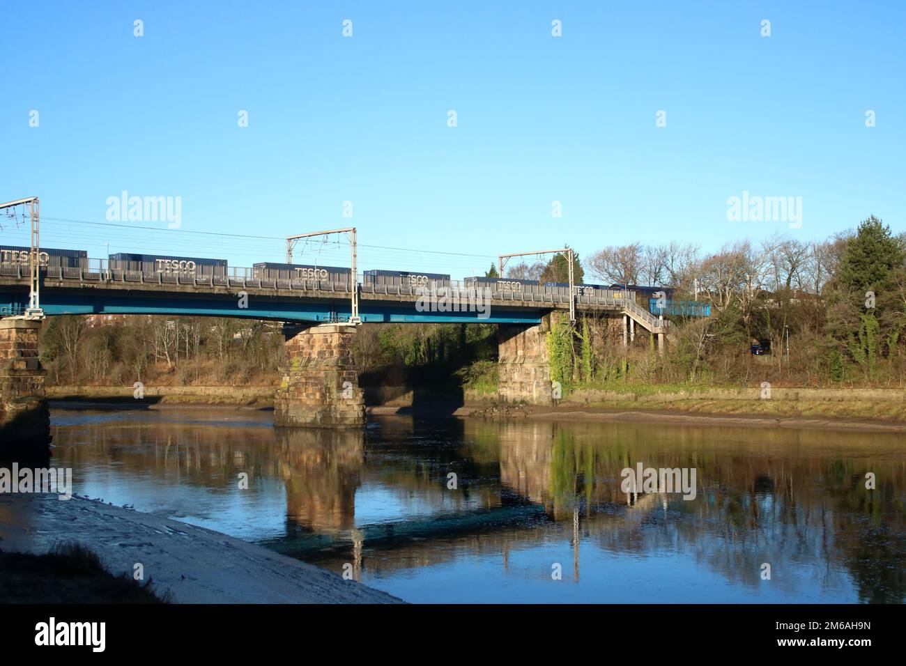 Container (Tesco train) hauled by Direct Rail Services class 66 diesel loco on WCML on Carlisle Bridge River Lune in Lancaster on 2nd January 2023. Stock Photo