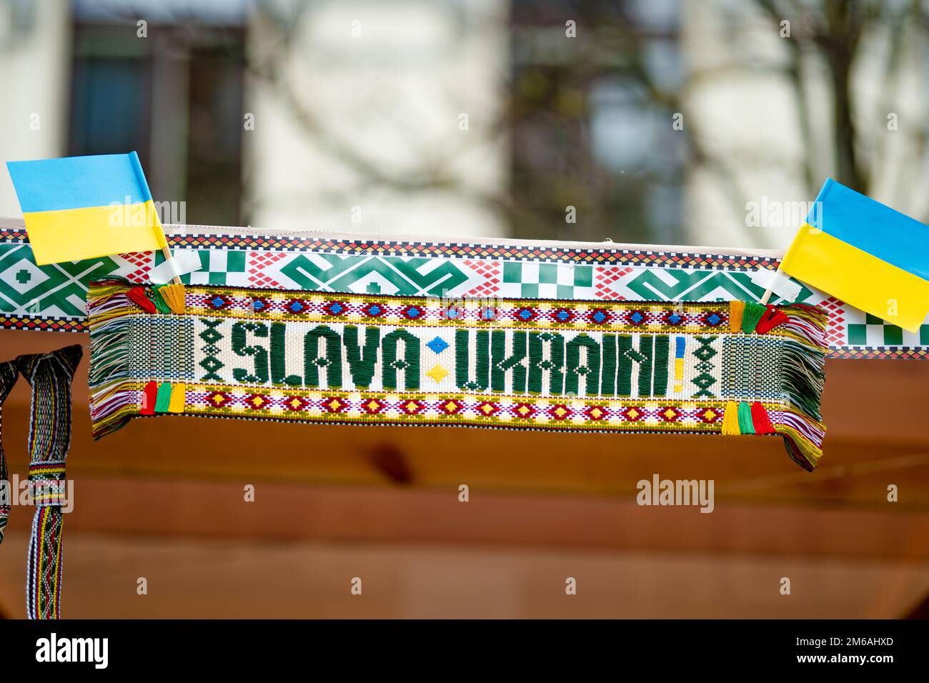 Ukrainian flags on a traditional Easter fair in Lithuania. Lithuanians support Ukrainian people. Colorful Lithuanian weave saying 'Glory to Ukraine'. Stock Photo