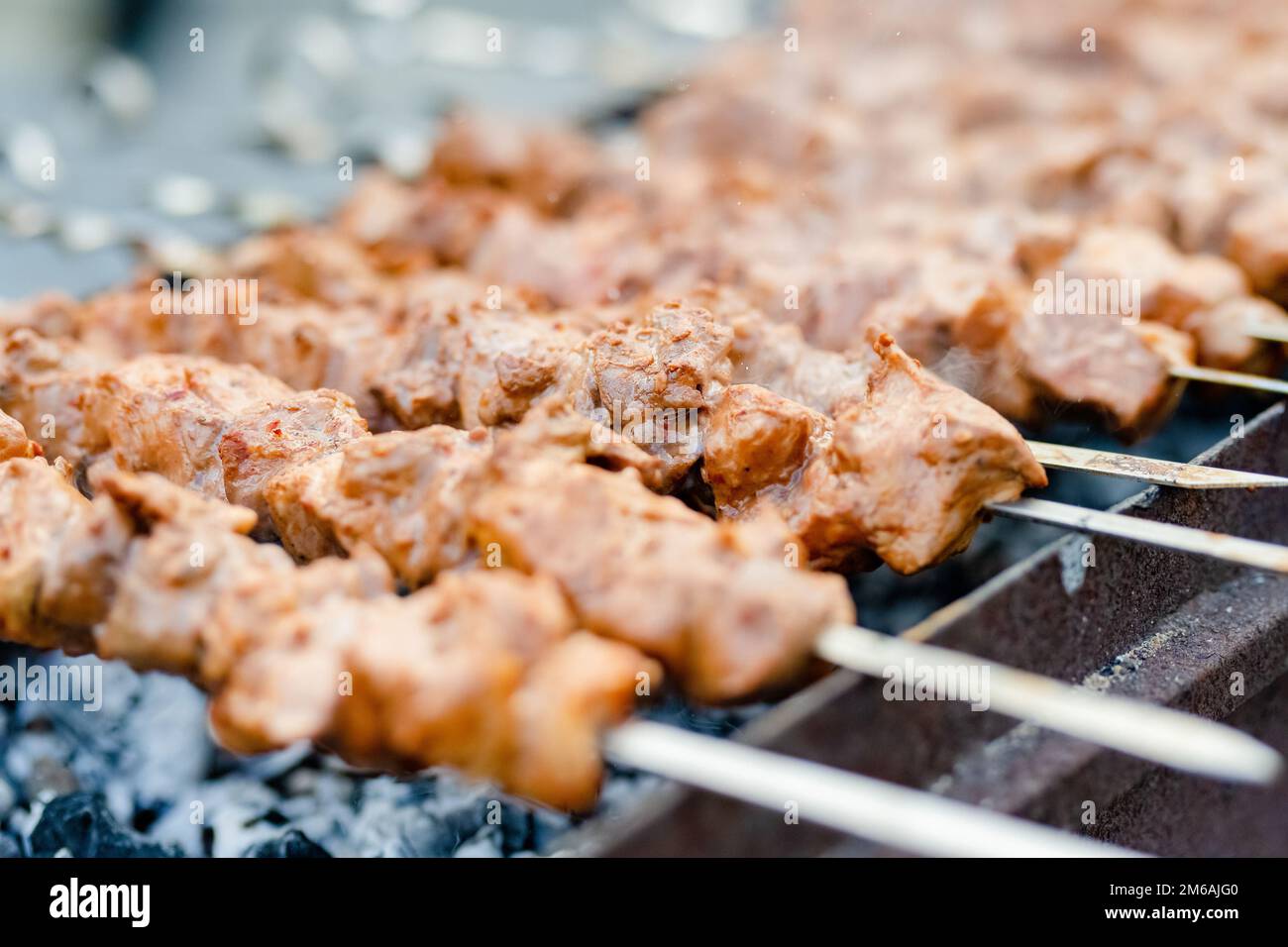 Grilling marinated shashlik on a grill. Shashlik is a form of Shish kebab  popular in Eastern, Central Europe and other places. Shashlyk meaning skewer  Stock Photo - Alamy