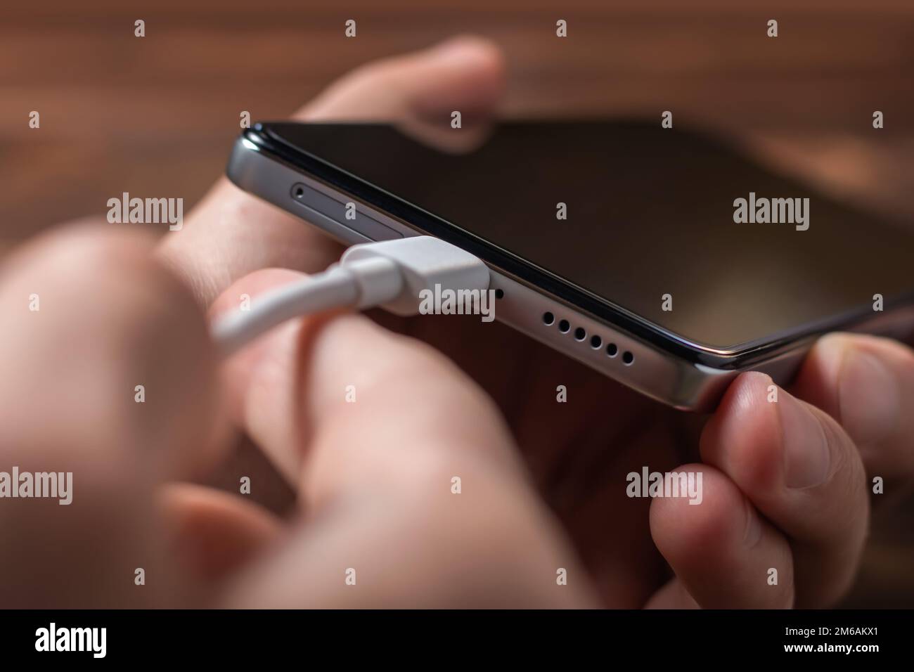 Man hands plugging a charger in a smart phone. Man using smartphone