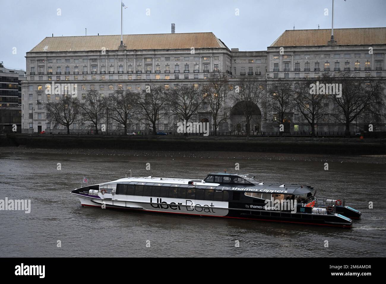 An Uber boat passes Thames House, Mi5 headquarters, in central London. January 2023. Stock Photo