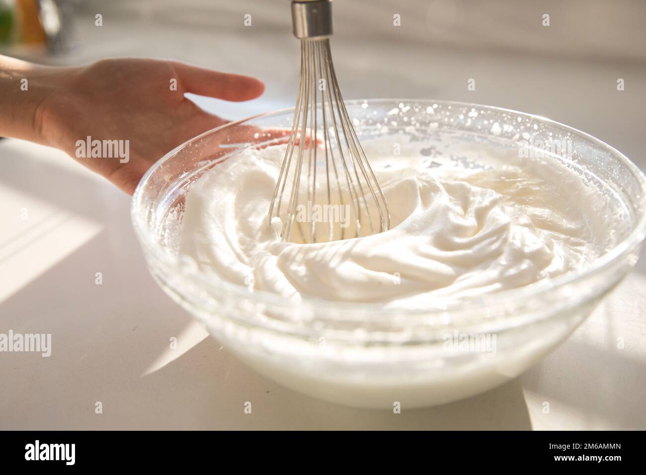 Beating a white cream with a mixer in a metal bowl. Whipped cream. Cream  for the cake Stock Photo - Alamy