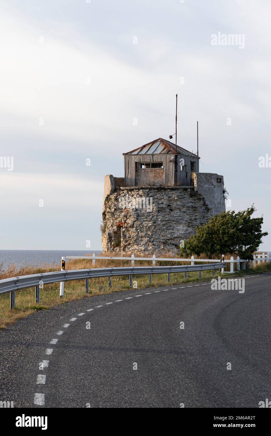 Coastal road and ruins of the historic lighthouse in the evening light on the cliff on Pakri Peninsula, Harju County, Estonia Stock Photo