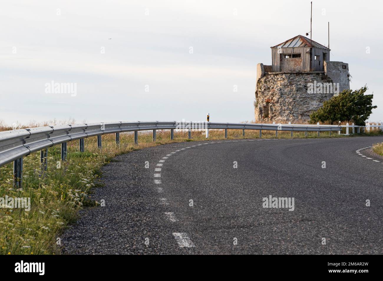 Coastal road and ruins of the historic lighthouse in the evening light on the cliff on Pakri Peninsula, Harju County, Estonia Stock Photo