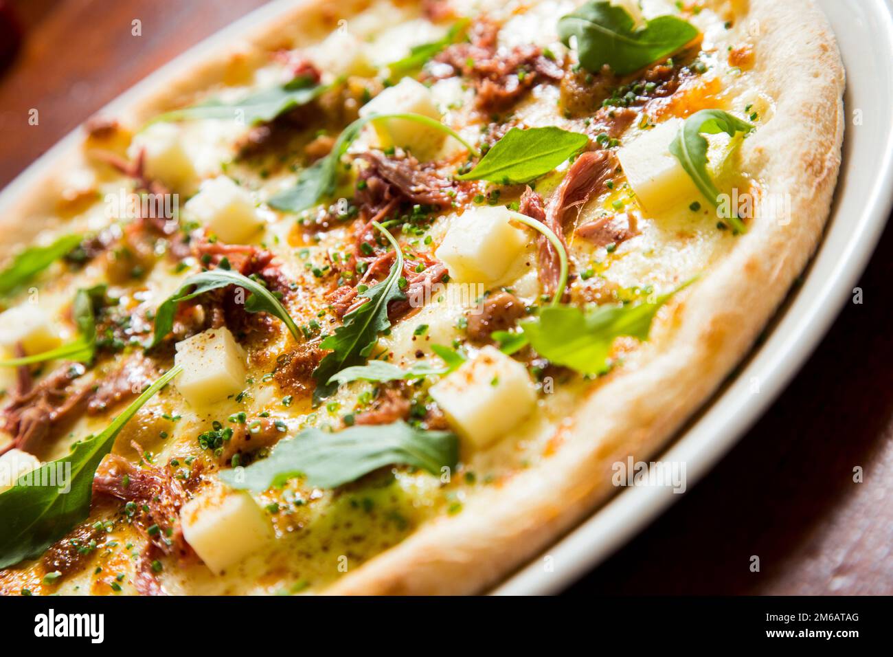 Pizza with arugula meat and cheese. Neapolitan pizza made with