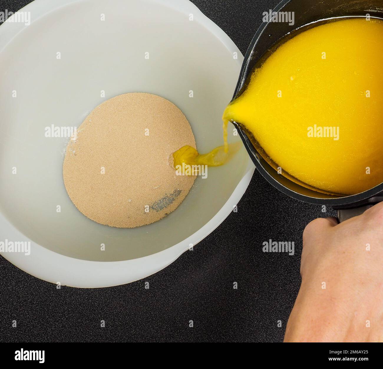 Hand pouring melted butter Stock Photo Alamy