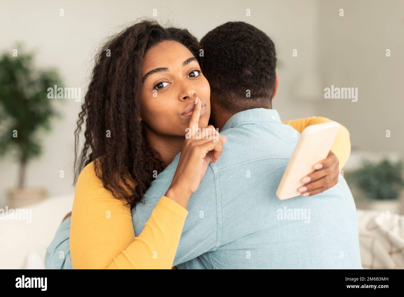 Glad millennial african american wife hugging husband, show silence ...