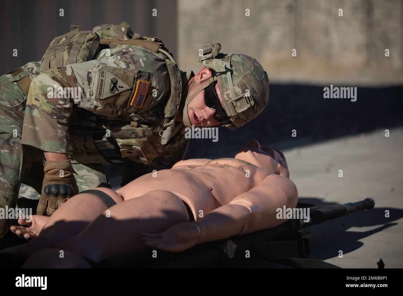 Spc. Jason Yoder, Headquarters Headquarters Company, 1st Battalion, 6th Infantry Regiment, checks his casualty for wounds as part of the nine-line medevac lane in the 1st Armored Division Iron Squad competition, April 22, 2022, on Fort Bliss, Texas. The Iron Squad Competition is a four-day event designed to test each squad and individual competitor’s physical stamina, Warrior Tasks and Battle Drill skills, and military knowledge. The winning squad will advance to compete in the III Corps Best Squad Competition later this year at Fort Hood. Stock Photo