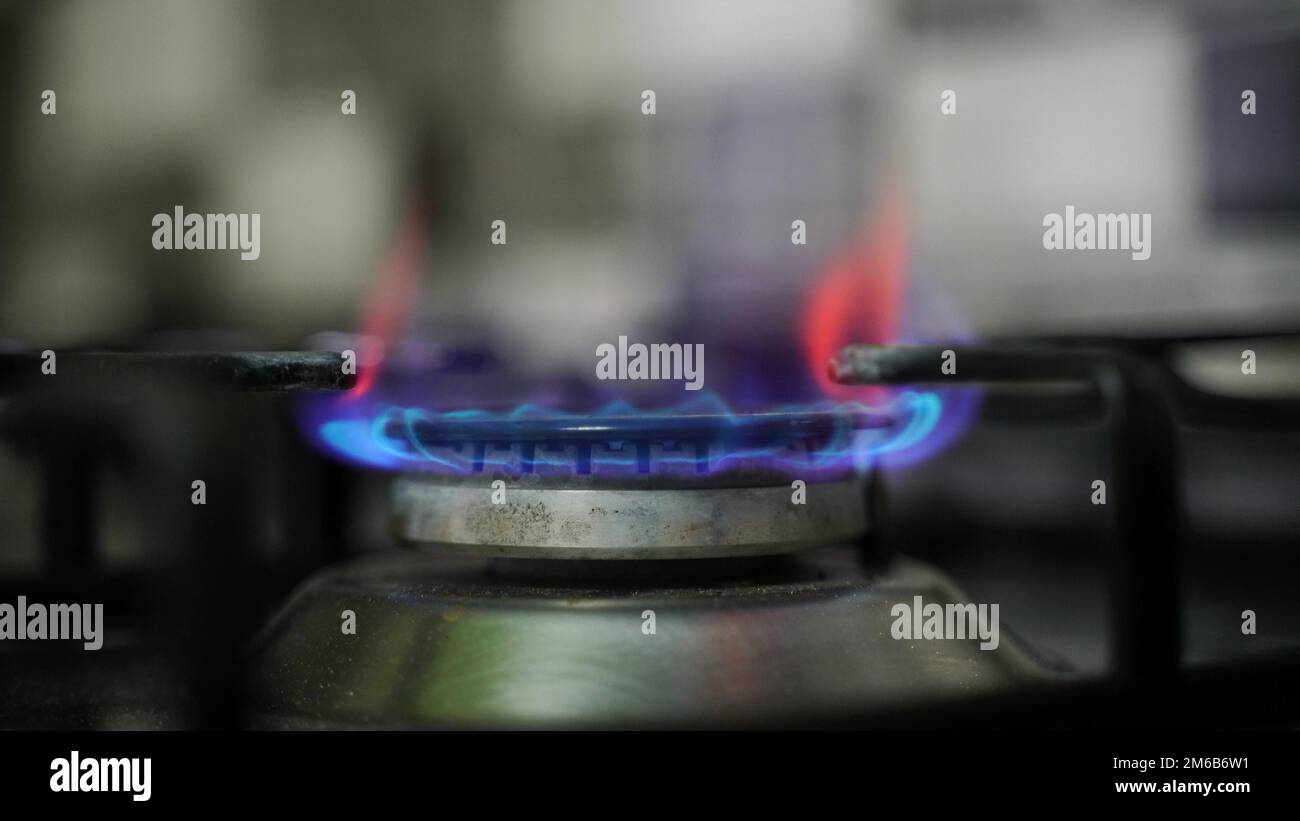 Kitchen burner turning on. Stove top burner igniting into a blue