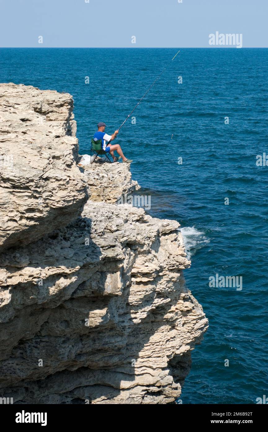 Fishing on the rocks Stock Photo