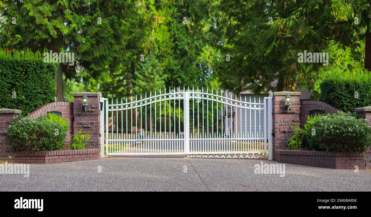 Double wroughtiron gate. Wrought iron gate and stone pillar. White