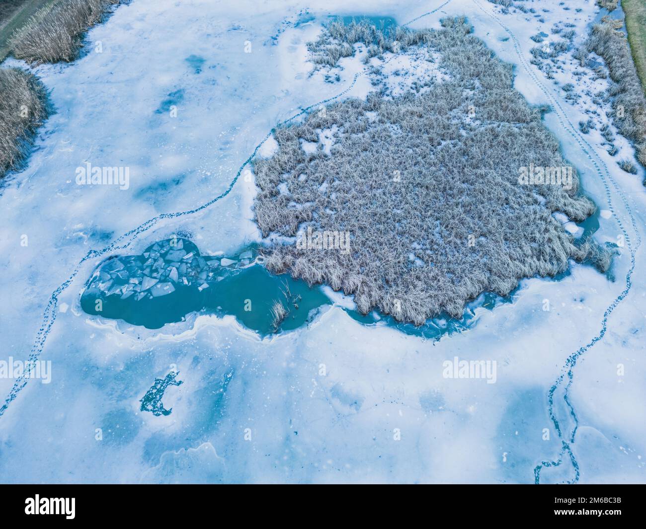 Panoramic aerial view of a frozen lake with animal footprints. Animal tracks on the frozen surface of the lake Stock Photo