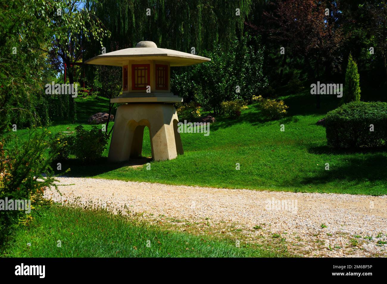Miniature concrete watch tower at park near footpath within trees and grass in a sunny summer day Stock Photo