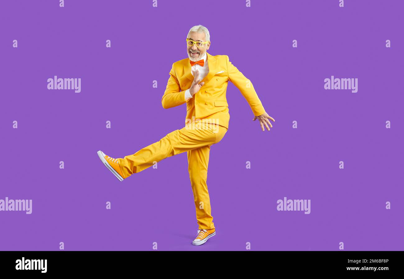 Smiling energetic old man dancing in studio Stock Photo