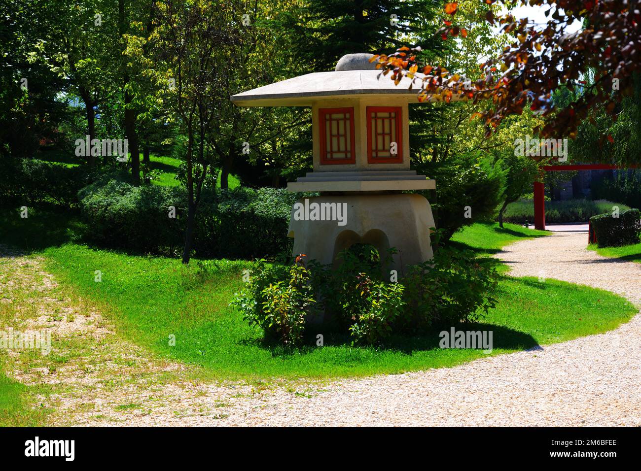Miniature concrete watch tower at park near footpath within trees and grass in a sunny summer day Stock Photo
