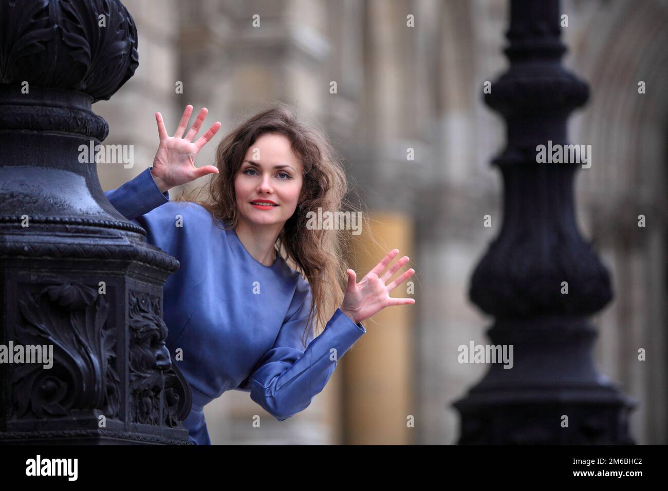 Beautiful elegant woman hiding behind a lantern and making a surprised antic Stock Photo