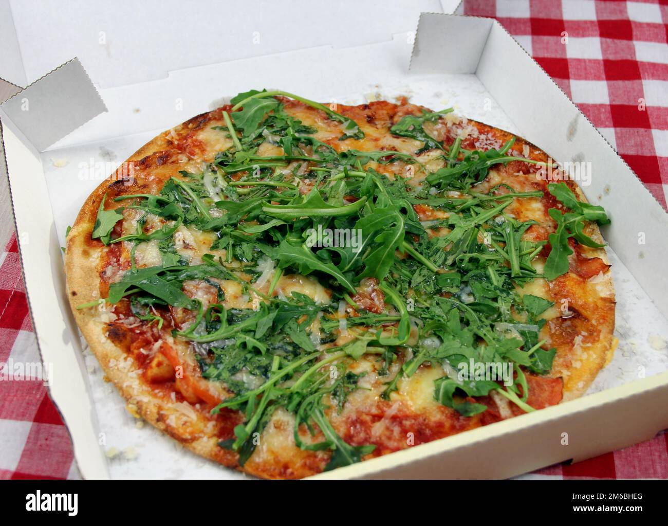 Vegetarische Pizza mit Rucola, Tomaten und Parmesan im Pappkarton Stock ...