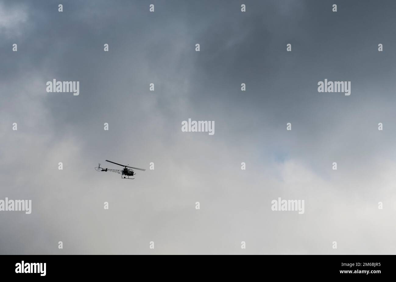 Helicopter hovering in stormy sky - shallow Stock Photo