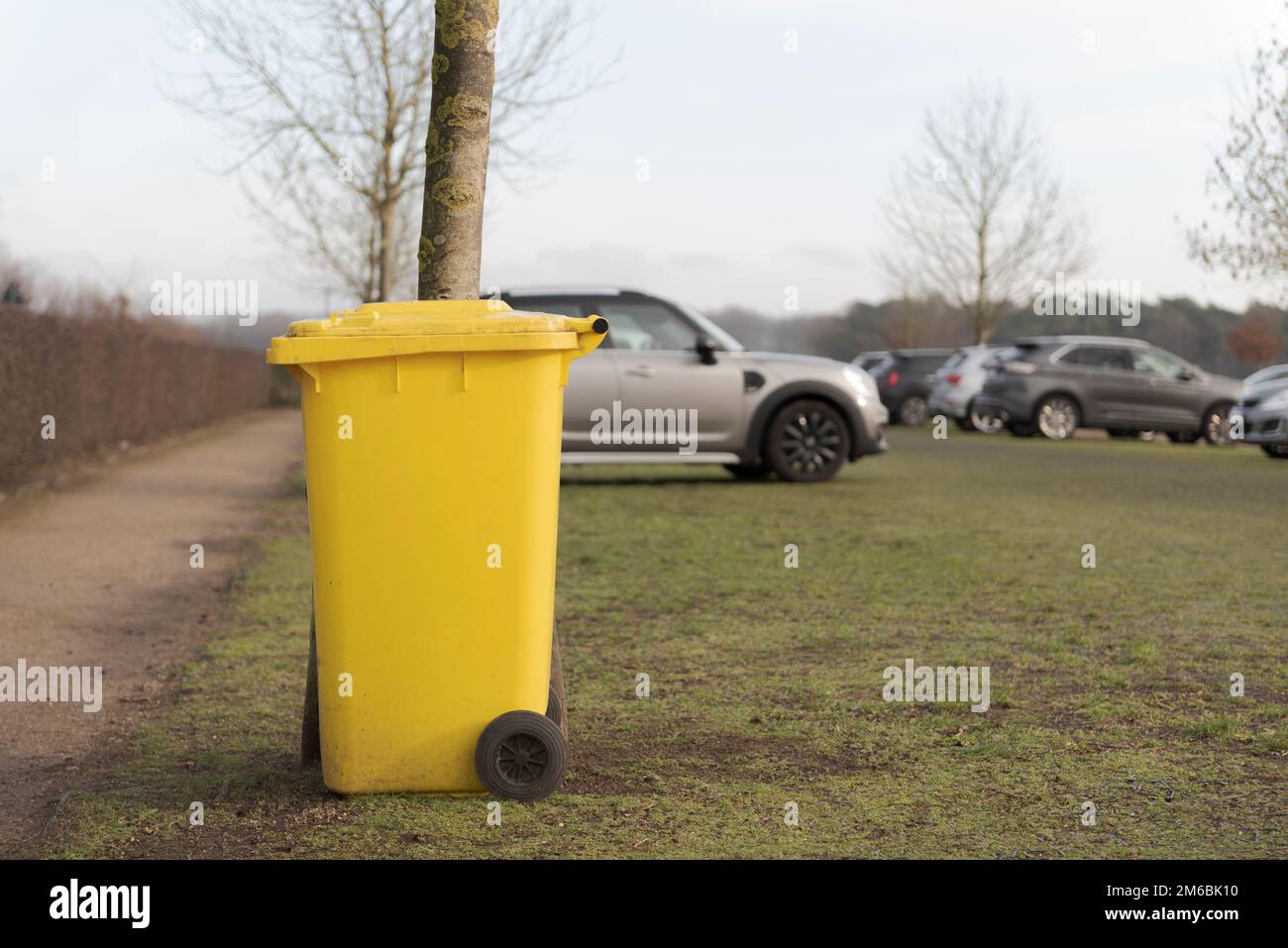 Yellow trash can in the car park Stock Photo