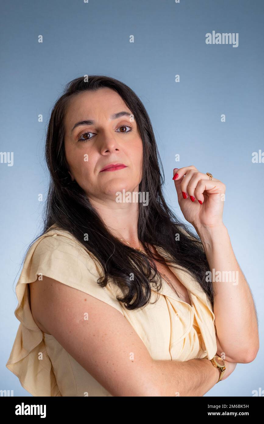 Young businesswoman, lawyer, with her hands close to her face. Isolated against light gray background. Stock Photo